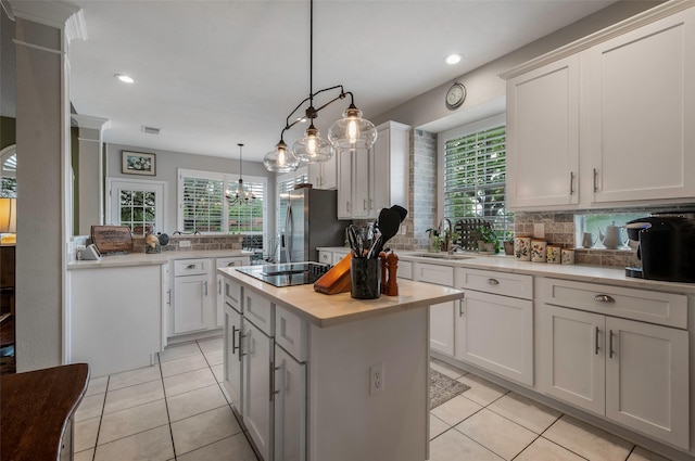 901 Brown Trl, Coppell, TX 75019 - kitchen featuring stainless steel fridge with ice dispenser, a center island, light tile patterned flooring, light countertops, and plenty of natural light