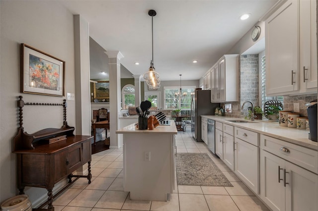 901 Brown Trl, Coppell, TX 75019 - kitchen featuring stainless steel appliances, a center island, light countertops, light tile patterned floors, and pendant lighting