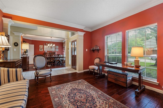 901 Brown Trl, Coppell, TX 75019 - living room featuring ornate columns, wood-type flooring, a chandelier, ornamental molding, and a textured ceiling