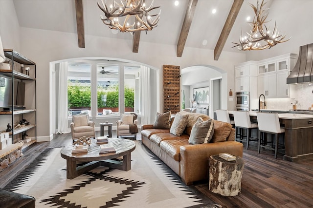 15111 Spider Lily Rd, Frisco, TX 75035 - living area featuring arched walkways, a chandelier, dark wood-style floors, beam ceiling, and a ceiling fan