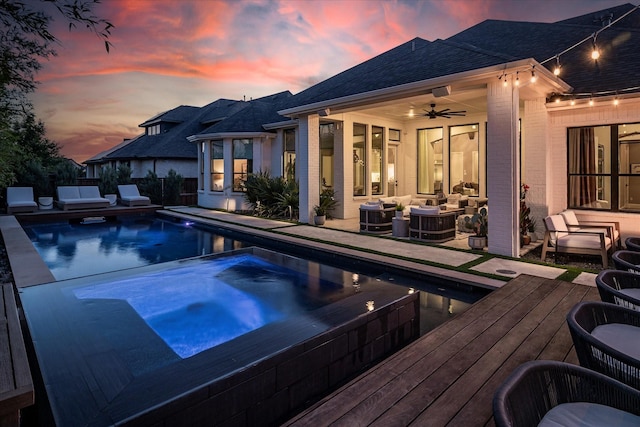 15111 Spider Lily Rd, Frisco, TX 75035 - pool at dusk with outdoor lounge area, a ceiling fan, a deck, and a pool with connected hot tub