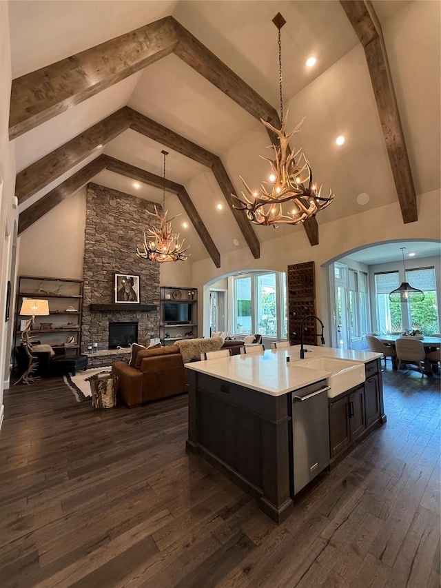 15111 Spider Lily Rd, Frisco, TX 75035 - kitchen with a chandelier, stainless steel dishwasher, a fireplace, arched walkways, and beam ceiling