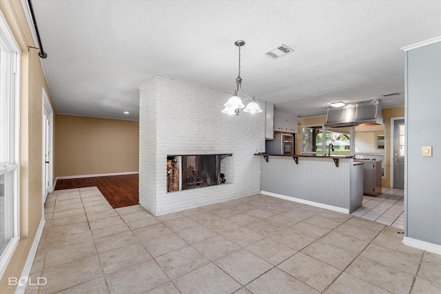 858 River Rd, Shreveport, LA 71105 - unfurnished living room featuring light tile patterned flooring, a fireplace, a chandelier, and a textured ceiling