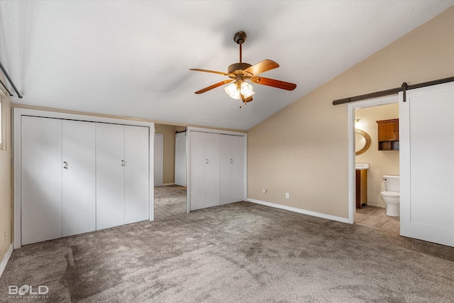858 River Rd, Shreveport, LA 71105 - unfurnished bedroom featuring multiple closets, lofted ceiling, carpet floors, a barn door, and ensuite bathroom