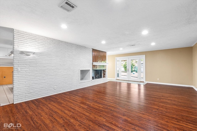 858 River Rd, Shreveport, LA 71105 - unfurnished living room with wood finished floors, recessed lighting, a brick fireplace, and a textured ceiling