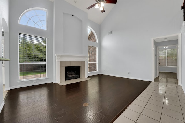 8504 Beatton Ct, Plano, TX 75025 - unfurnished living room featuring high vaulted ceiling, ceiling fan, a fireplace, wood finished floors, and arched walkways
