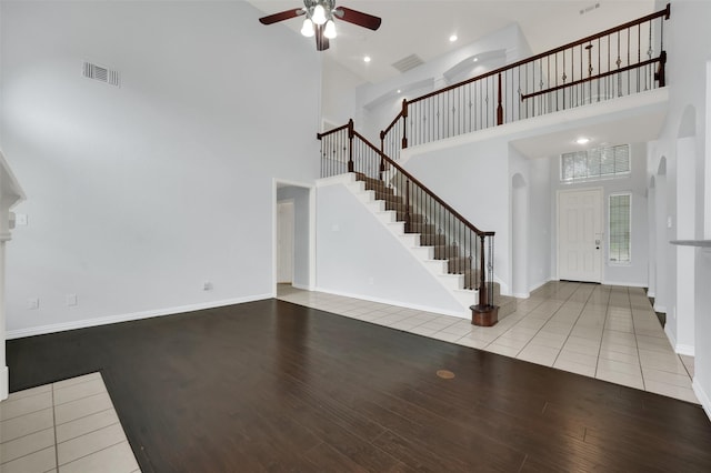 8504 Beatton Ct, Plano, TX 75025 - foyer entrance featuring a towering ceiling, stairway, ceiling fan, wood finished floors, and arched walkways