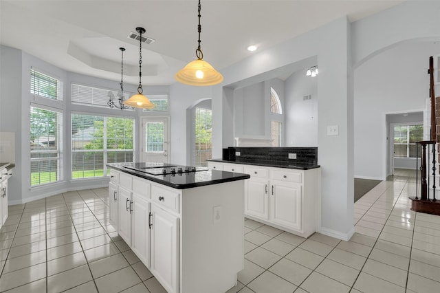 8504 Beatton Ct, Plano, TX 75025 - kitchen featuring arched walkways, light tile patterned floors, dark countertops, a kitchen island, and recessed lighting