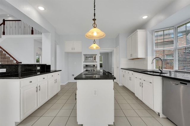 8504 Beatton Ct, Plano, TX 75025 - kitchen with stainless steel appliances, a kitchen island, decorative backsplash, white cabinets, and pendant lighting