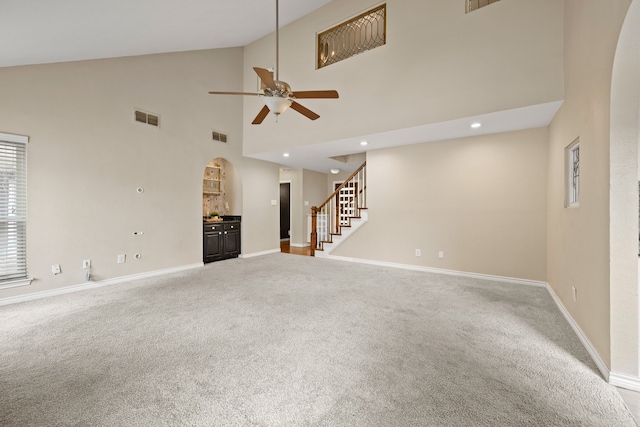 4147 Woodside Knl, Grapevine, TX 76051 - unfurnished living room featuring arched walkways, carpet, stairway, ceiling fan, and high vaulted ceiling