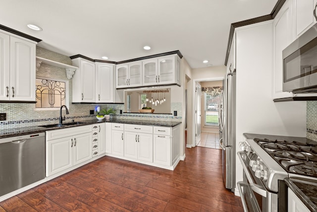 4147 Woodside Knl, Grapevine, TX 76051 - kitchen featuring appliances with stainless steel finishes, tasteful backsplash, dark wood finished floors, glass insert cabinets, and white cabinets