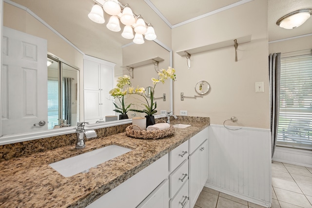 4147 Woodside Knl, Grapevine, TX 76051 - bathroom featuring double vanity, tile patterned floors, a wainscoted wall, and crown molding