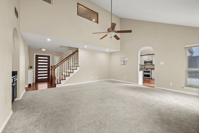 4147 Woodside Knl, Grapevine, TX 76051 - unfurnished living room featuring carpet, high vaulted ceiling, arched walkways, ceiling fan, and stairs