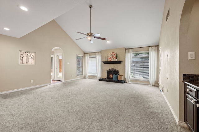 4147 Woodside Knl, Grapevine, TX 76051 - unfurnished living room featuring a fireplace, ceiling fan, high vaulted ceiling, light carpet, and arched walkways