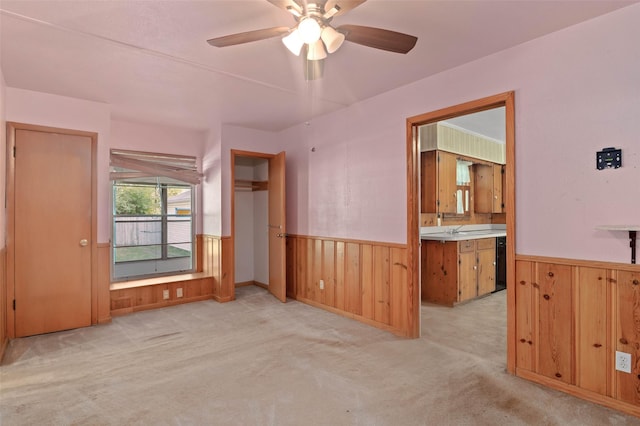 10230 Kilkenny Pl, Dallas, TX 75228 - spare room featuring a wainscoted wall, wood walls, light carpet, and a ceiling fan