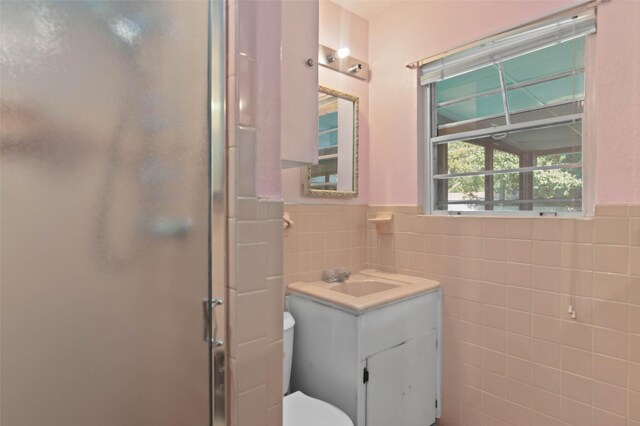 10230 Kilkenny Pl, Dallas, TX 75228 - bathroom featuring a stall shower, vanity, tile walls, and a wainscoted wall