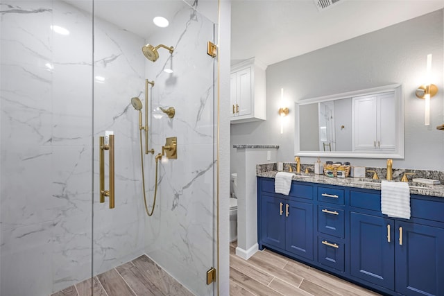 7909 Quest Ct, Frisco, TX 75035 - bathroom featuring double vanity, a marble finish shower, and wood tiled floors