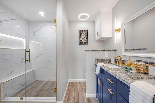 7909 Quest Ct, Frisco, TX 75035 - bathroom with a marble finish shower, wood finished floors, and vanity