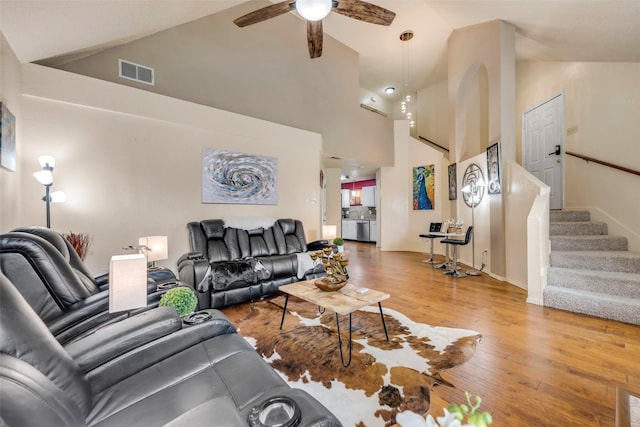 7909 Quest Ct, Frisco, TX 75035 - living room featuring light wood-style floors, ceiling fan, stairway, and high vaulted ceiling