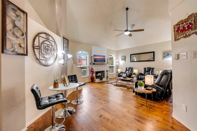 7909 Quest Ct, Frisco, TX 75035 - living room featuring ceiling fan, vaulted ceiling, a warm lit fireplace, and hardwood / wood-style flooring