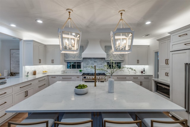 7402 Centenary Ave, Dallas, TX 75225 - kitchen featuring a chandelier, premium range hood, appliances with stainless steel finishes, a breakfast bar area, and recessed lighting