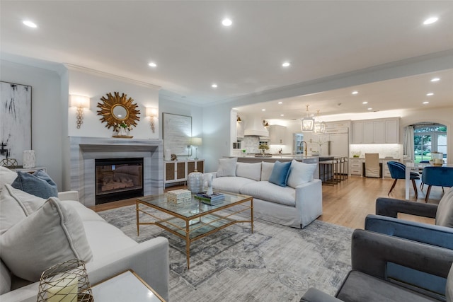 7402 Centenary Ave, Dallas, TX 75225 - living area with light wood-style floors, crown molding, recessed lighting, and a glass covered fireplace
