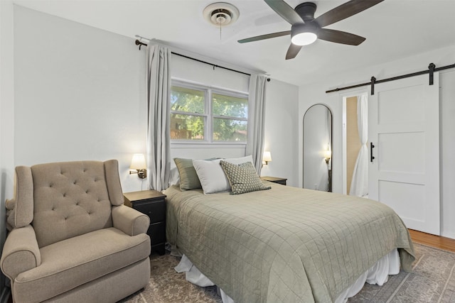 7516 Deaver Dr, North Richland Hills, TX 76180 - bedroom featuring a barn door, wood finished floors, and ceiling fan