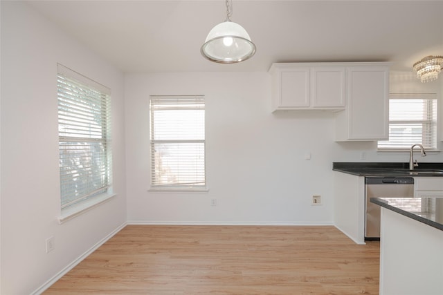 2912 Lighthouse Dr, Denton, TX 76210 - kitchen with stainless steel dishwasher, white cabinetry, dark countertops, light wood-style flooring, and plenty of natural light