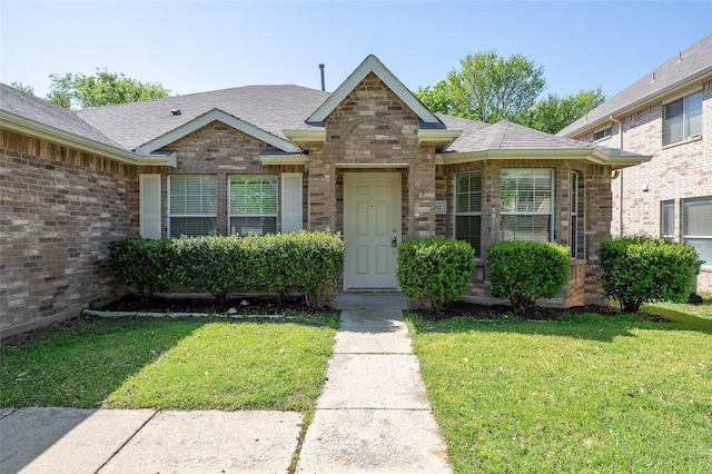 2912 Lighthouse Dr, Denton, TX 76210 - view of front facade featuring a front lawn, a shingled roof, and brick siding