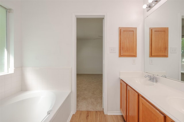 2912 Lighthouse Dr, Denton, TX 76210 - bathroom featuring double vanity, a bath, and wood finished floors