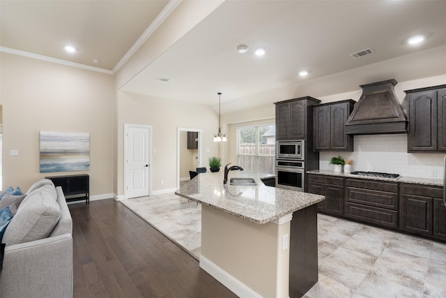 1809 Camo Ct, Allen, TX 75002 - kitchen featuring stainless steel appliances, custom exhaust hood, light stone countertops, open floor plan, and a center island with sink