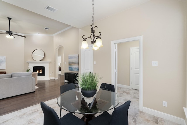 1809 Camo Ct, Allen, TX 75002 - dining room featuring a ceiling fan, a chandelier, a lit fireplace, ornamental molding, and light wood finished floors