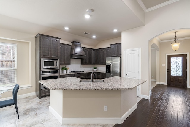 1809 Camo Ct, Allen, TX 75002 - kitchen with appliances with stainless steel finishes, premium range hood, arched walkways, healthy amount of natural light, and crown molding