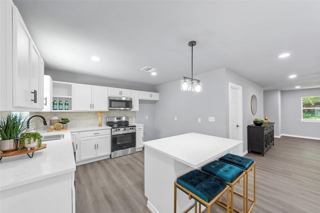 2473 W Five Mile Pkwy, Dallas, TX 75233 - kitchen featuring stainless steel appliances, open shelves, light wood finished floors, backsplash, and recessed lighting