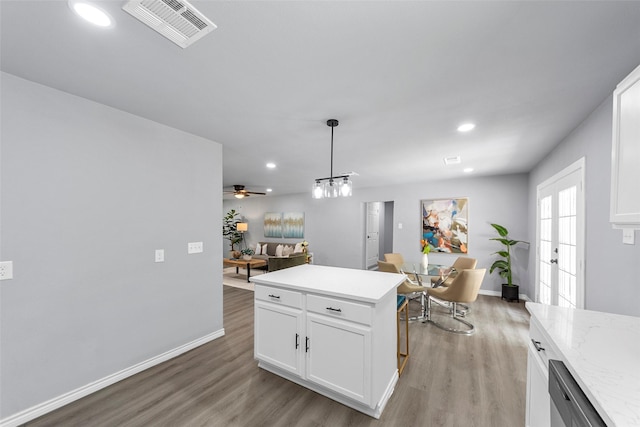 2473 W Five Mile Pkwy, Dallas, TX 75233 - kitchen with light wood-style flooring, recessed lighting, white cabinetry, open floor plan, and pendant lighting