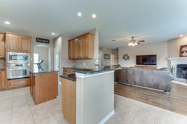 1684 Tannerson Dr, Rockwall, TX 75087 - kitchen featuring appliances with stainless steel finishes, light tile patterned flooring, a center island, recessed lighting, and a ceiling fan