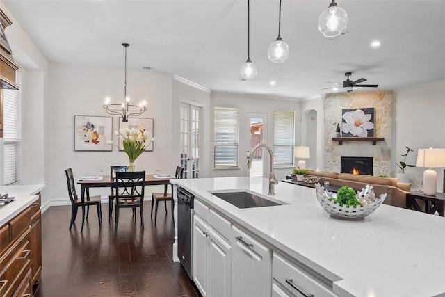 2542 Morgan Ln, Trophy Club, TX 76262 - kitchen with a stone fireplace, dark wood-style floors, stainless steel dishwasher, light countertops, and ornamental molding