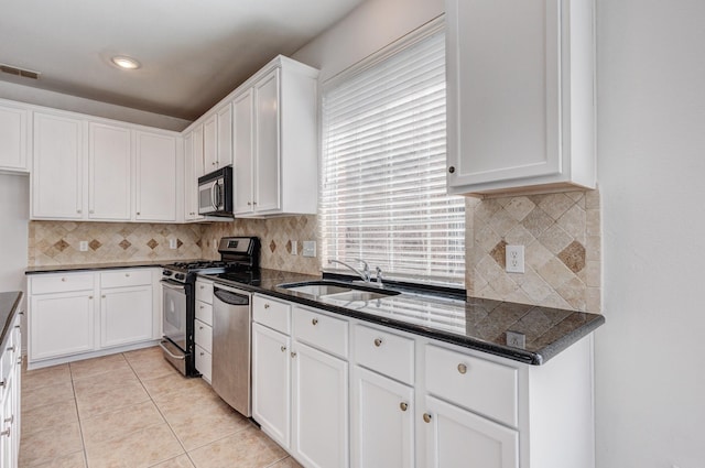 7101 Bickers Dr, Rowlett, TX 75089 - kitchen with appliances with stainless steel finishes, white cabinetry, backsplash, light tile patterned flooring, and recessed lighting