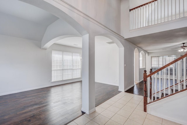 7101 Bickers Dr, Rowlett, TX 75089 - entrance foyer with wood finished floors, a ceiling fan, stairs, vaulted ceiling, and arched walkways