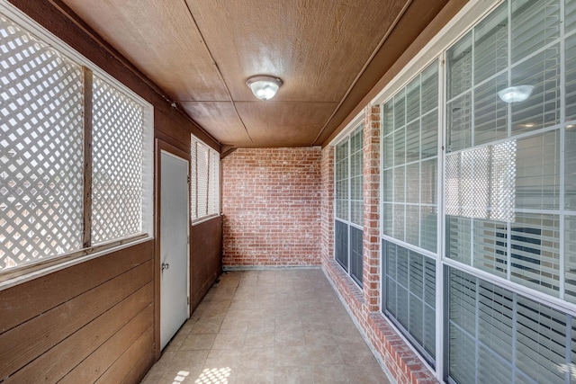 7101 Bickers Dr, Rowlett, TX 75089 - unfurnished sunroom featuring brick wall, wood ceiling, plenty of natural light, and wooden walls