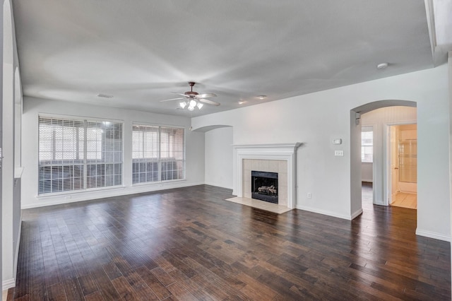 7101 Bickers Dr, Rowlett, TX 75089 - unfurnished living room featuring a ceiling fan, plenty of natural light, arched walkways, and wood finished floors