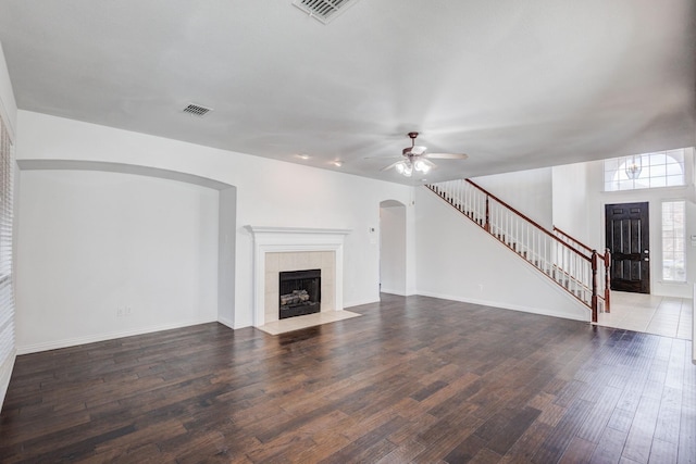 7101 Bickers Dr, Rowlett, TX 75089 - unfurnished living room with a ceiling fan, arched walkways, stairs, wood finished floors, and a fireplace