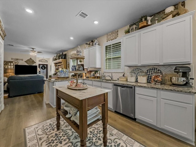 2332 Evening Stone Dr, Little Elm, TX 76227 - kitchen with stainless steel dishwasher, ceiling fan, a peninsula, decorative backsplash, and light wood-style flooring