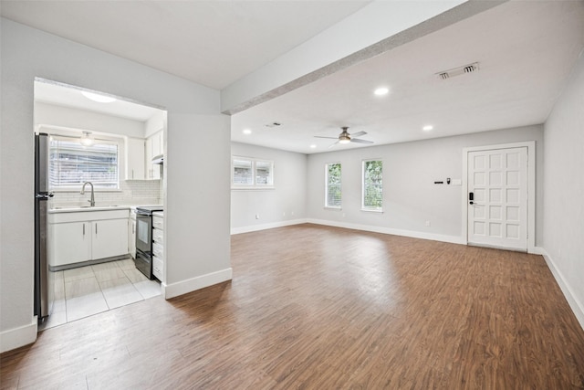 2529 W 12th St, Dallas, TX 75211 - unfurnished living room featuring a ceiling fan, recessed lighting, and light wood-style flooring