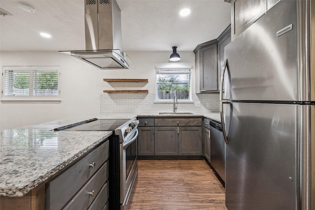 2529 W 12th St, Dallas, TX 75211 - kitchen featuring appliances with stainless steel finishes, island range hood, dark wood-style flooring, tasteful backsplash, and recessed lighting