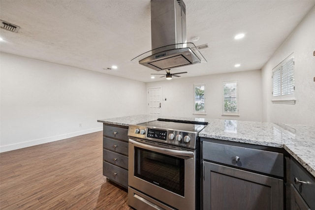 2529 W 12th St, Dallas, TX 75211 - kitchen with stainless steel electric range oven, island exhaust hood, dark wood-style flooring, a ceiling fan, and light stone countertops