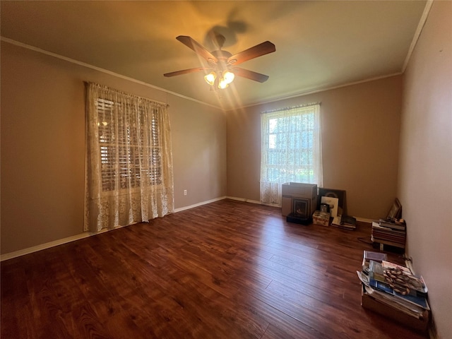 717 N 37th St, Corsicana, TX 75110 - spare room featuring ornamental molding, a wood stove, a ceiling fan, and wood finished floors
