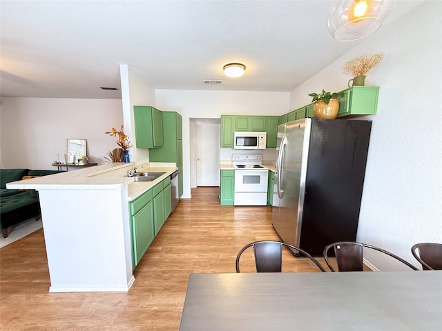 3541 Cripple Creek Trl, Fort Worth, TX 76262 - kitchen with green cabinets, white appliances, light wood-type flooring, light countertops, and a peninsula