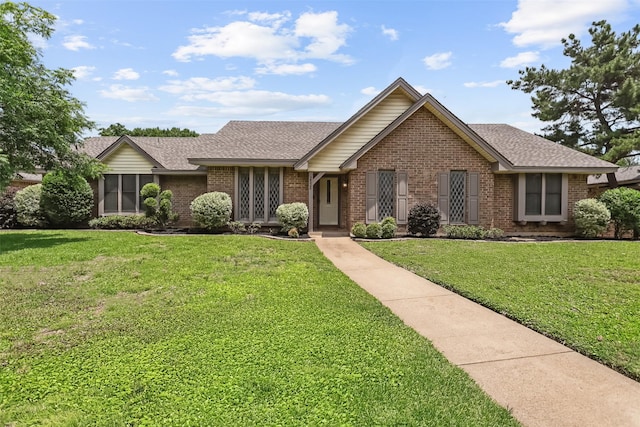 2526 Axminster Dr, Grand Prairie, TX 75050 - ranch-style house with brick siding, a front lawn, and a shingled roof