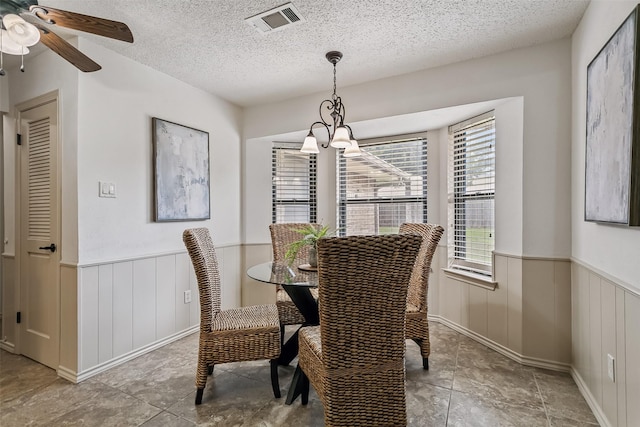 2526 Axminster Dr, Grand Prairie, TX 75050 - dining area featuring wainscoting, a textured ceiling, and ceiling fan